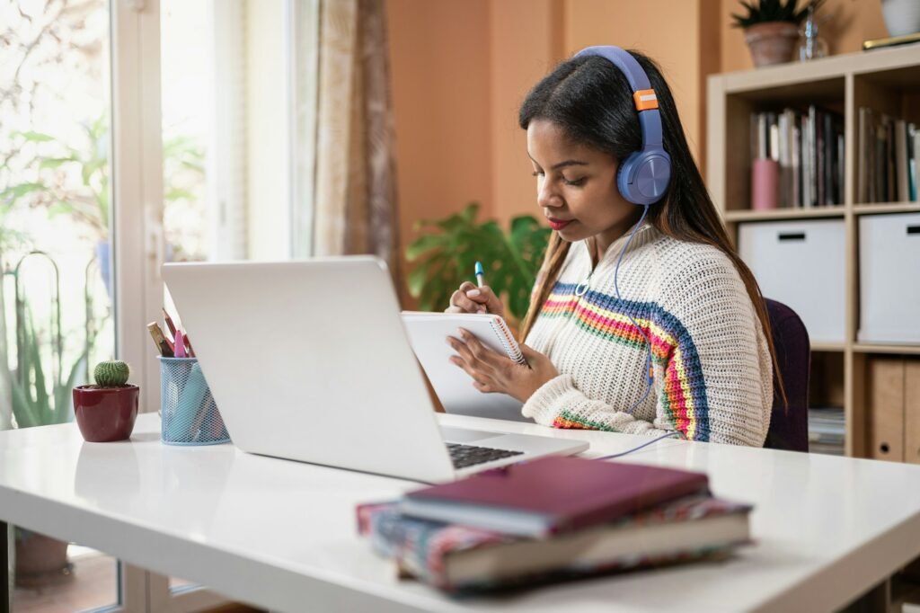 Latin American teenager girl taking notes and studying for the University Exams at home